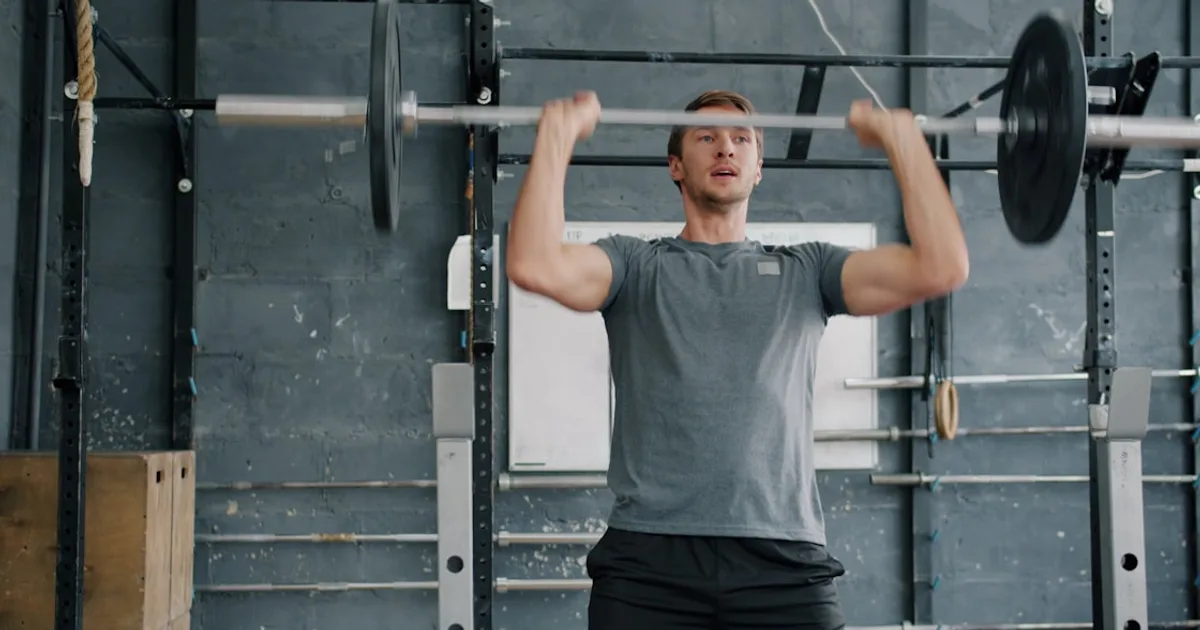 Atleta realizando un thruster con barra como ejercicio funcional de CrossFit