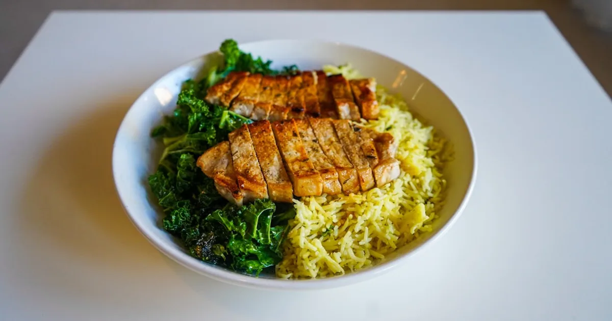 Bowl proteico de pollo con arroz, verduras y aguacate para deportistas